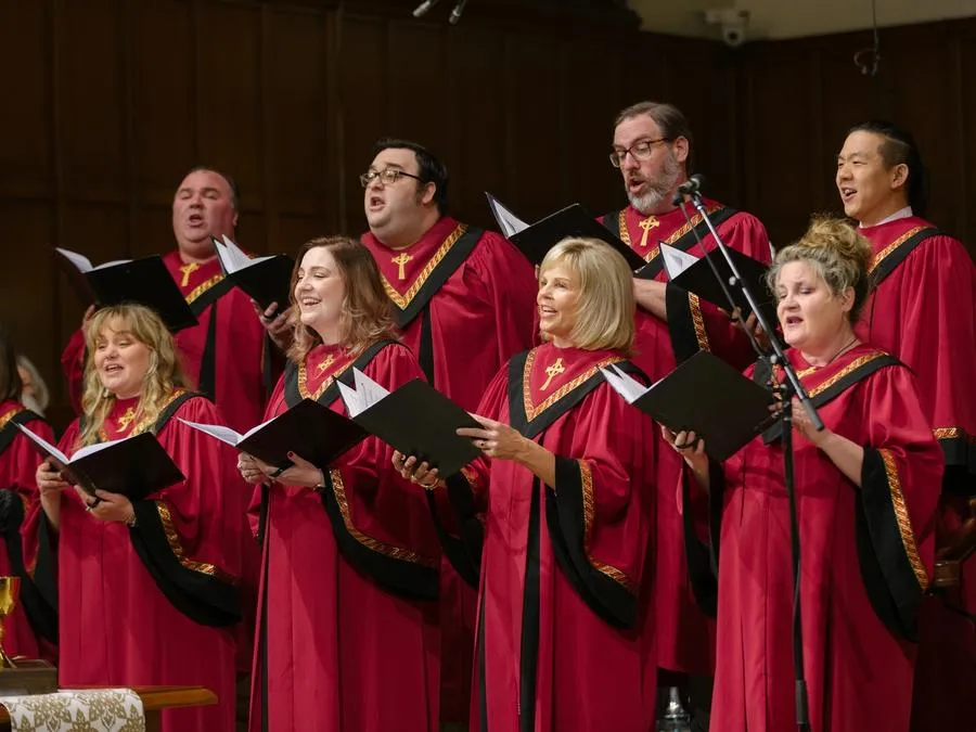Nine members of The Ensemble sing in red robes at the front of the SMCC sanctuary.