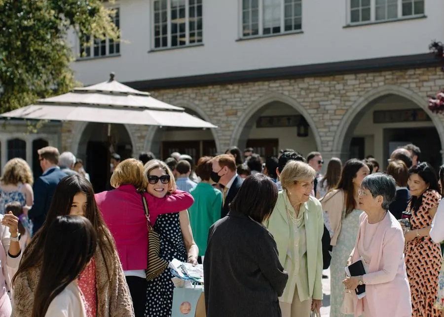 Groups of women in dresses greet one another in the courtyard at SMCC at mid-day.