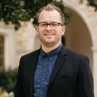 Jonas Streffer, Director of Digital Ministries. A smiling man with blonde hair wearing a blue shirt and black sport coat.