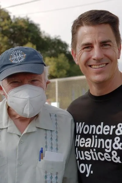 A masked SMCC member and Rev. Dr. Erik Wiebe stand together and smile.